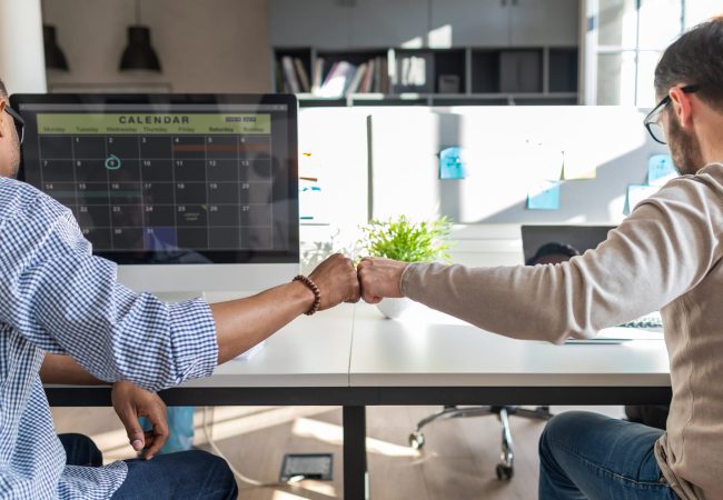 First bump between colleagues at work. Success in business. Everyday work in the office.